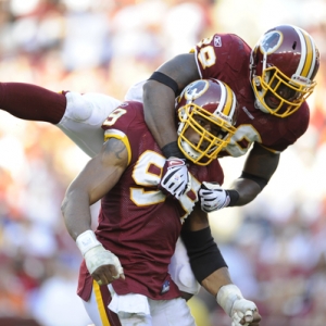 Redskins No. 98 Brian Orakpo jumps on No.  99 Andre Carter