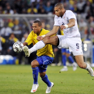Oguchi Onyewu (white) and Luis Fabiano (yellow) battle for a loose ball.